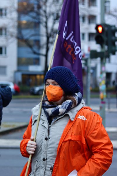 Eine Aktivistin von junges Attac hält eine junges Attac-Fahne