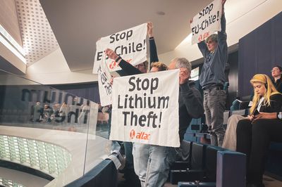 Mehrere Aktivist*innen halten auf der Besuchertribüne des Europäischen Parlamentes Banner hoch, auf Deneen "Stop EU-Chile!" und "Stop Lithium Theft!" steht