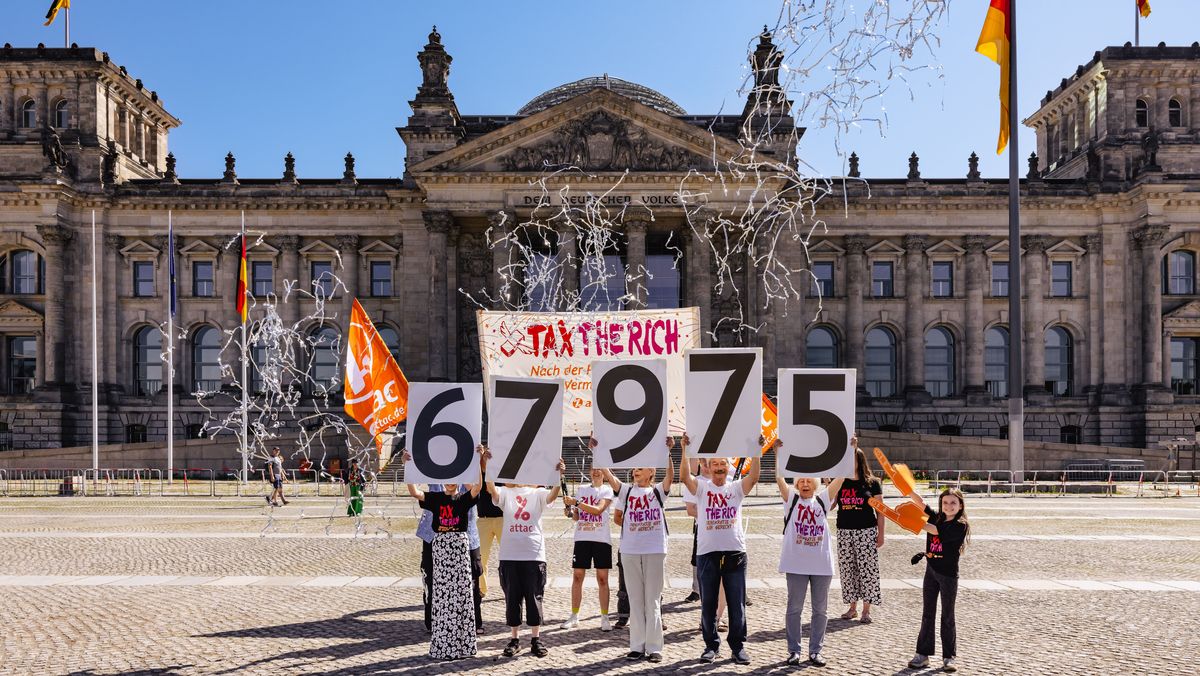 Vor dem Reichstag stehen Attacis, die mit großen Schildern die Zahl 67975 hochhalten
